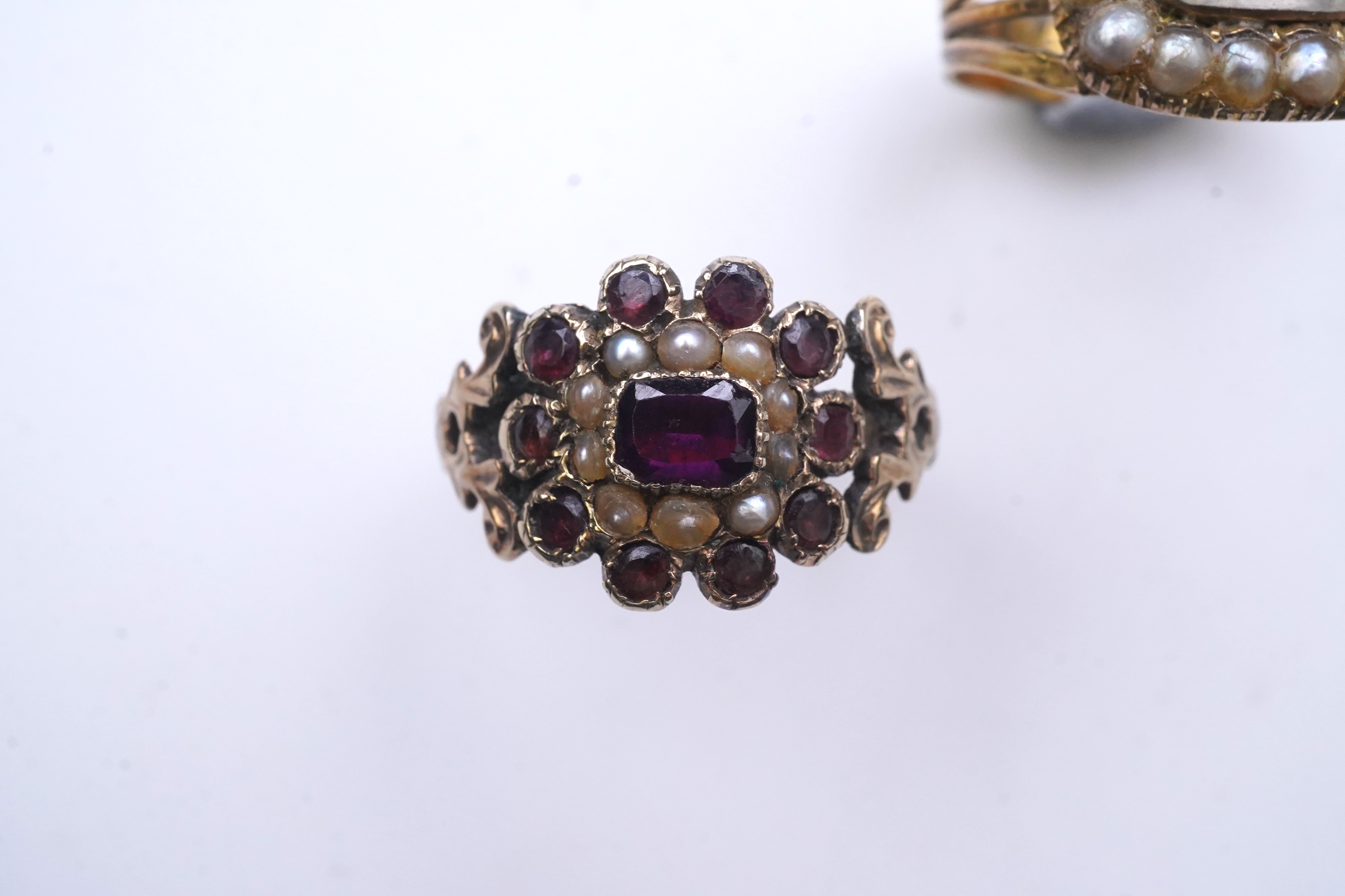 A George III seed pearl mourning ring and a garnet and seed pearl ring, mid 19th century